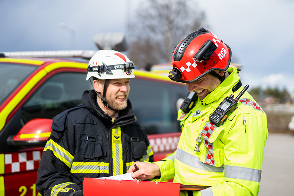 En brandman och en brandkvinna vid en brandbil