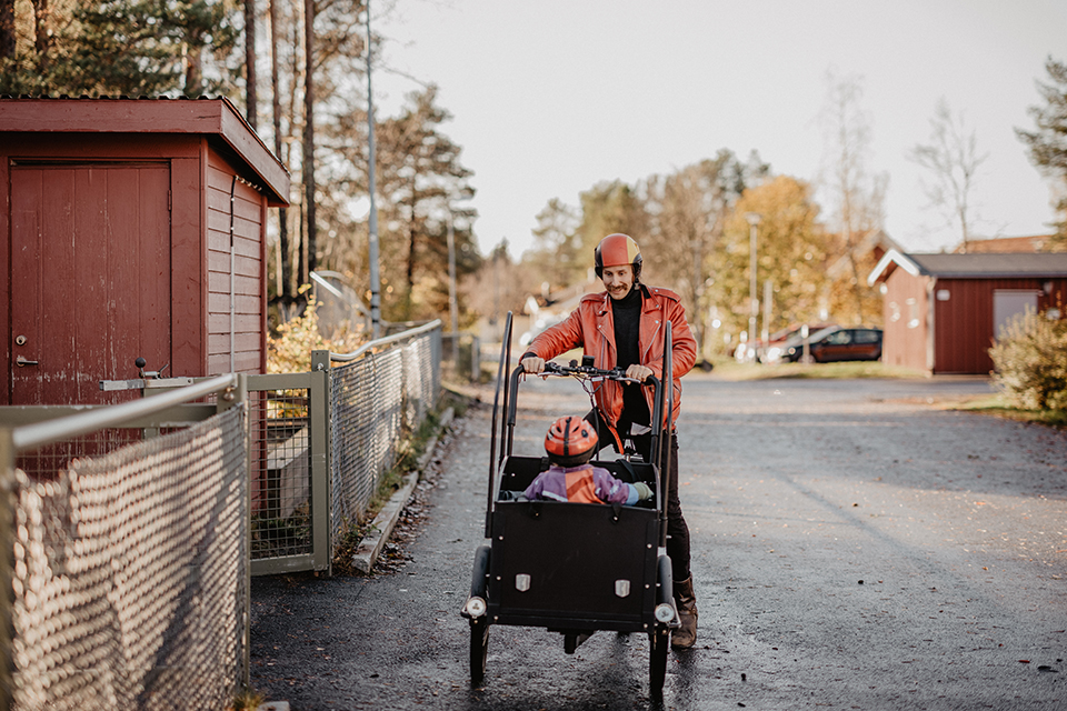 En pappa som lämnar sitt barn på förskola, med hjälp av lådcykel.