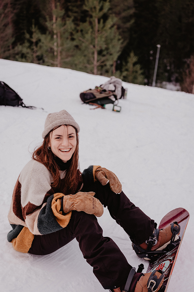 En ung kvinna som återhämtar sig efter ett snowboardåk.