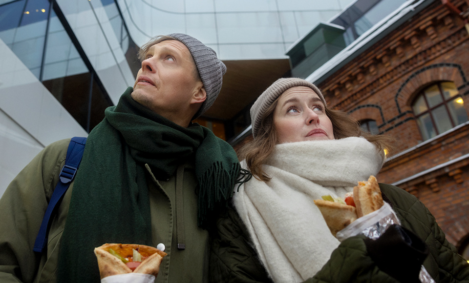 Man och kvinna tittar åt olika håll vid Väven/Stora hotellet i Umeå