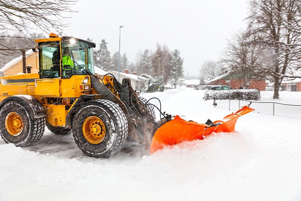 Gul traktor skottar snö.