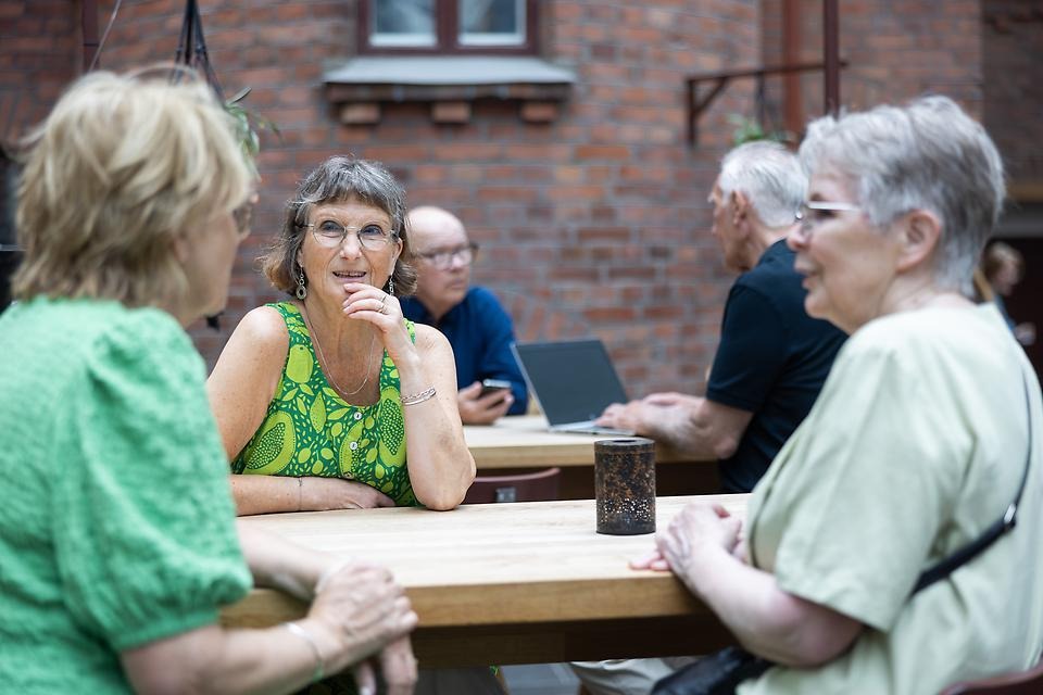Människor som umgås kring ett bord i utomhusmiljö
