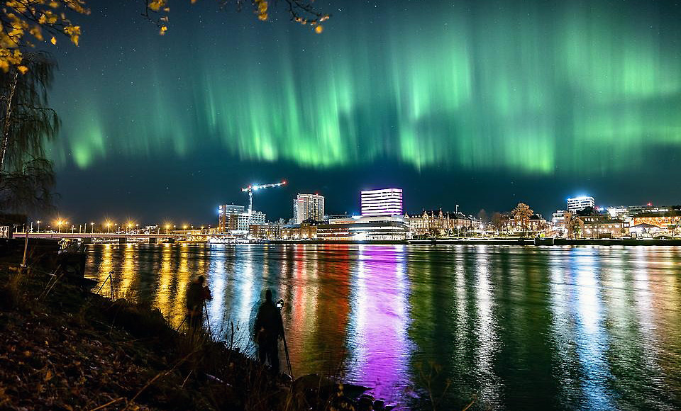 Umeå sett från älven med norrsken på himlen