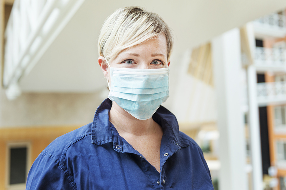 Kvinnlig vårdpersonal med munskydd