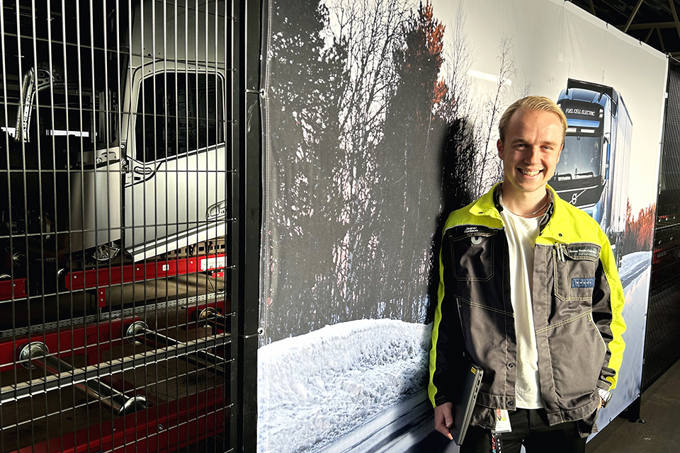 Jesper standing by a Volvo Trucks poster