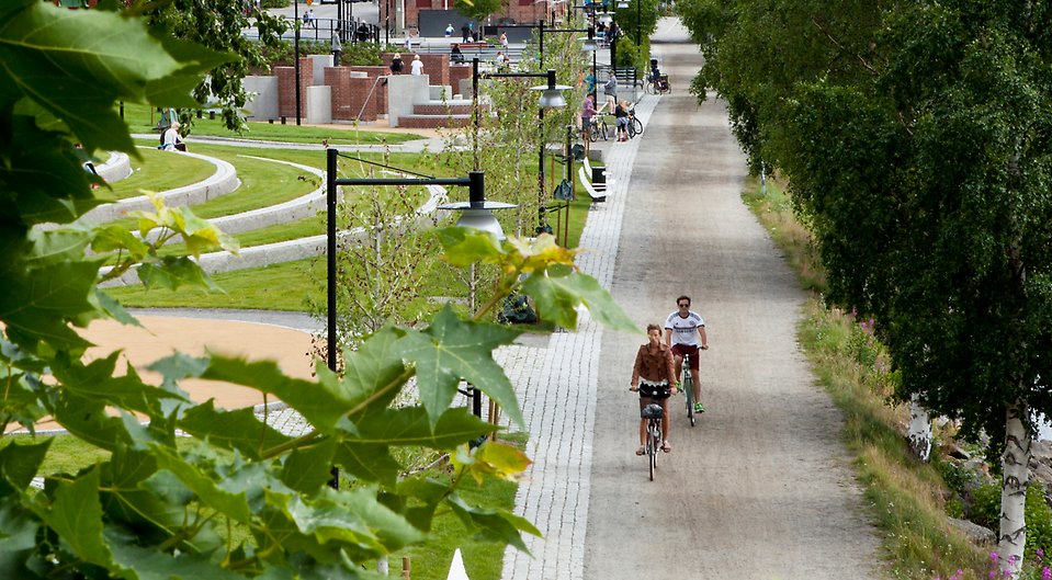 Broparken och strandpromenaden med två cyklister.en sommardag.
